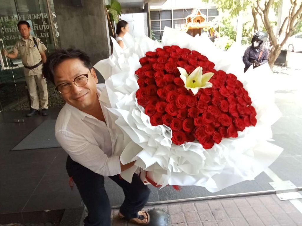 Red rose heart bouquet with white lilies from BestBloomBuddy, featuring 100 vibrant roses arranged in a romantic heart shape.