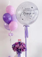 Violet orchid flower in a decorative flower box from BestBloomBuddy, showcasing vibrant petals and lush green leaves.